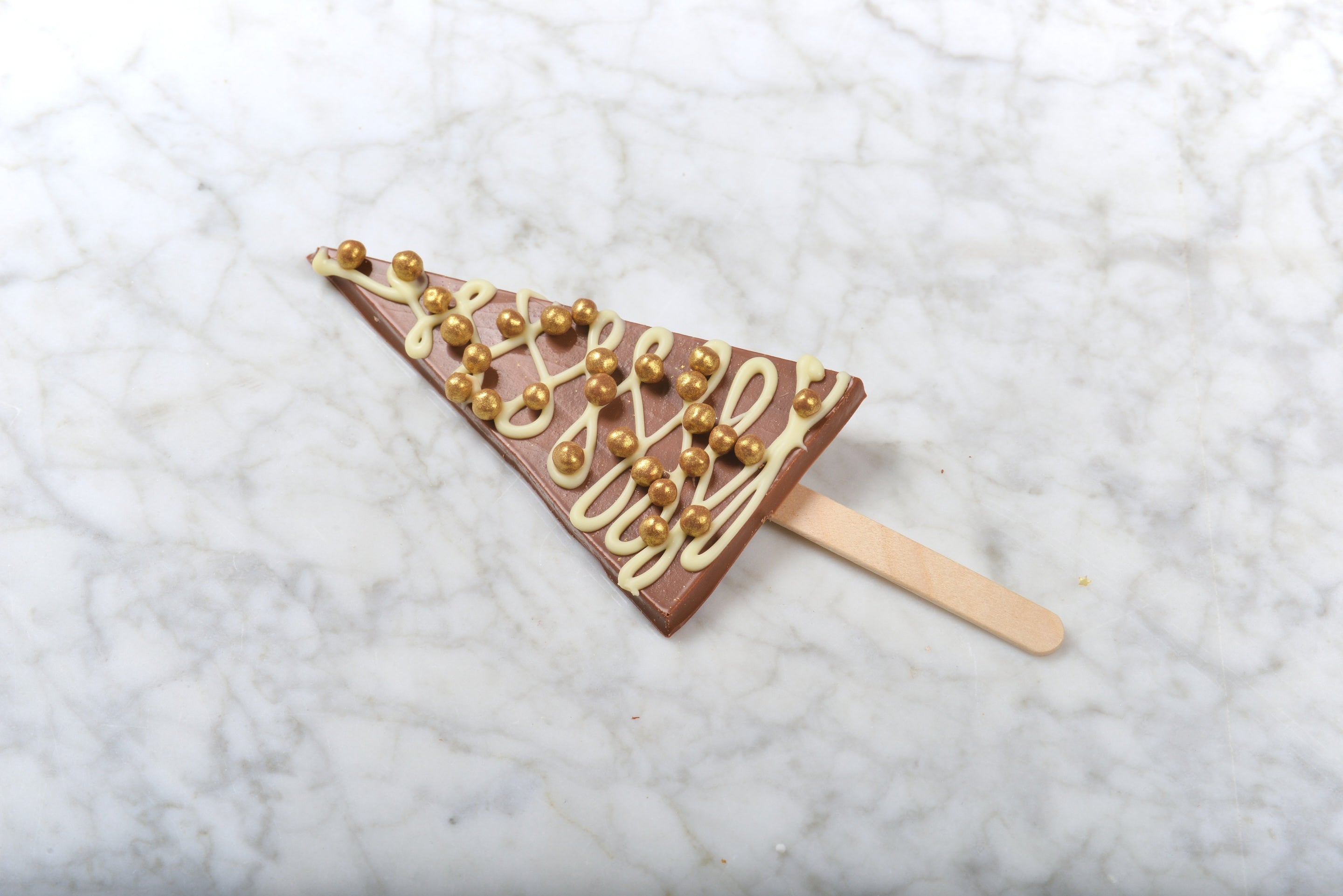 Kerstboom op stokje - melkchocolade met crisppearls